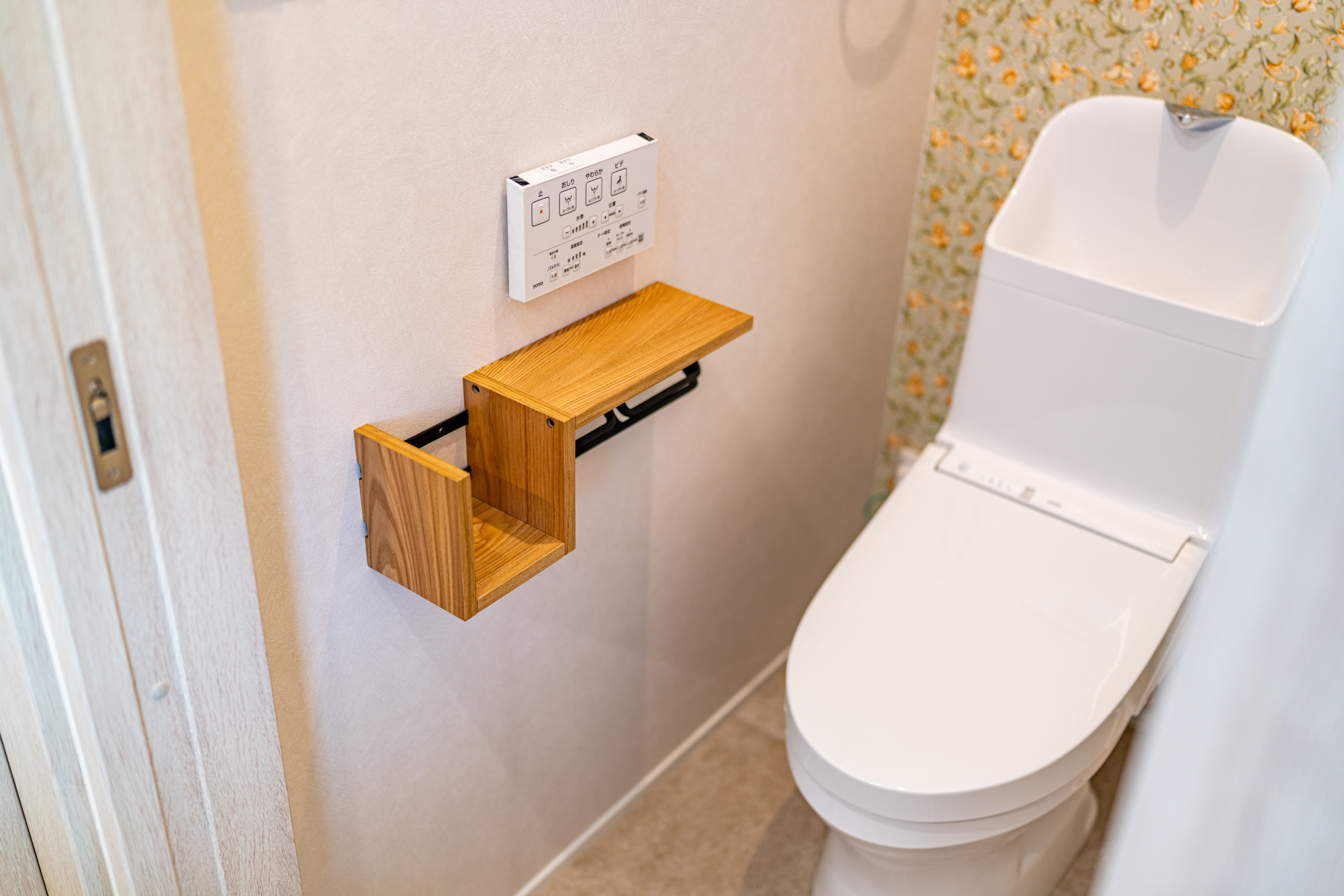 2階のトイレは家族だけが使う空間。ナチュラルなペーパーフォルダー(LOWYA)と、明るい花柄(サンゲツ FE76368)の壁紙で、華やかな雰囲気に仕上げました。